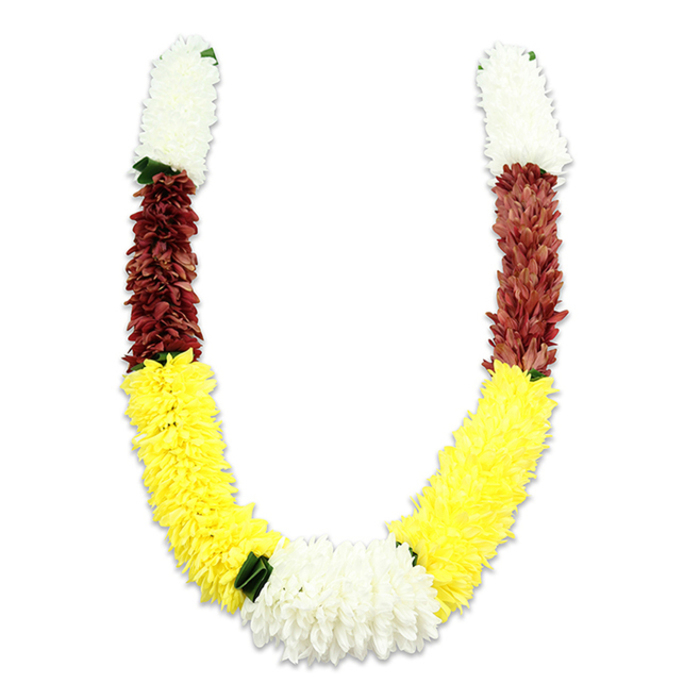 Set against a clean white backdrop, this U-shaped traditional floral garland presents an exacting sequence of colour and texture that reads as both ceremonial and celebratory - the sort of piece you might see supplied for temple offerings or community weddings in Harold Wood and nearby Romford Market stalls. Each arm begins with a dense, cylindrical section of creamy white blooms; their minute, overlapping petals produce a sensual, cottony volume reminiscent of chrysanthemums or small jasmine clusters, though the material is fabric and intended for durability. Immediately beneath these white crowns, a compact band of maroon or reddish-brown petals introduces a deep, contemplative hue that contrasts beautifully with the lighter tones. The longest portion along the lower curve is a bright, emphatic yellow - plush, sun-bright flowers stitched closely together to form the main body of the U and to radiate an uplifting warmth. At the very bottom centre, where the two yellow arcs meet, a broad, lush cluster of pure white chrysanthemum-like blooms forms a striking central motif, visually resolving the colour rhythm. Tiny dark green leaf-like accents punctuate selective joins between the segments, especially between the yellow and white sections, offering a restrained touch of greenery that helps each block read clearly. Close inspection reveals meticulous assembly: layers of fabric petals, hidden threadwork, and careful shaping that ensure a full, uniform silhouette. This garland's palette - white for purity, yellow for auspiciousness, maroon for devotion - is intentionally traditional, crafted for occasions from pooja to festive doorway decorations across Harold Wood and Gidea Park.