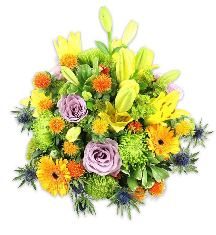 Against a pristine white backdrop, this abundant, rounded floral composition reads as both exuberant and elegantly balanced, a piece that blends traditional charm with unexpected botanical accents. Prominent yellow Asiatic lilies rise through the bouquet, their trumpet-shaped blooms speckled with tiny freckles and accented by the contrast between open blossoms and elongated chartreuse buds-a visual narrative of bloom and promise. Soft lavender roses sit slightly recessed, their tender swirls of petals offering a quiet, refined focal point that calms the warmer hues. Vivid orange Gerbera daisies, with their flat radiant faces and dark central discs, introduce bold, graphic notes that carry warmth across the design. The body of the arrangement is enriched with vivid lime-green button chrysanthemums, whose compact, ruffled clusters produce a textured, cushion-like mass and enhance the bouquet's fullness. Dotted among these are small, spiky globe-shaped orange and golden-yellow flowers that create lively, tactile interest. At the lower edges and peeking from between leaves, indigo to blue-grey Eryngium thistles contribute an architectural, almost marine-inspired contrast-sharp-edged bracts and globular centres that punctuate the softer shapes. A mix of foliage-from broad lily leaves to fine, glossy fillers-wraps and unifies the elements, creating depth and a sense of natural abundance. Bathed in soft natural light, the lilies and roses yield a faint fragrance that suggests spring and early summer. This composition would work beautifully as a vibrant centrepiece for a party near Harold Wood Park, an uplifting get-well bouquet delivered locally, or a versatile gift that speaks of careful craftsmanship and seasonal freshness.