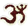 A reverent, hand-sculpted floral Om (Aum) sits against a pristine white backdrop, its form built from a dense carpet of small, deep maroon-red chrysanthemum-like blooms. Up close, each tiny head reveals a lime-green eye at the center, a delicate punctuation that livens the dark red field and gives the whole symbol a living, textured surface. The familiar '3'-like curve, the descending S-shaped stroke and the small crescent-and-dot are all carefully traced in this velvety red, while a thick, undulating frame of pure white spray chrysanthemums outlines and defines the negative spaces, making the sacred character read clearly from every angle. Soft studio light from above casts a subtle drop shadow beneath the composition, emphasizing its sculptural depth and the cool, silky feel one imagines when brushing fingers across the tightly packed petals. There is a quiet scent-earthy, slightly green, like late-summer gardens after rain-that seems to ground the piece, appropriate for moments of contemplation. As a local arrangement crafted with ceremonial respect, it reads as both art and devotion: suitable for a puja, meditation gathering, or a dignified memorial. Created with the careful hand of an experienced florist in our Harold Wood area studio, it connects to community life around Harold Wood station, Gidea Park and nearby Romford, offering a familiar local presence for those seeking floral tributes or spiritual décor. This image captures the patience and precision of floral artisanship, the tactile contrast of deep maroon and crisp white, and the peaceful intent embodied by the Om symbol.